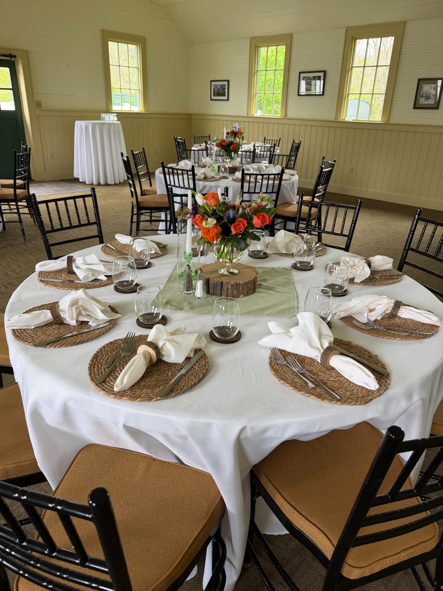 Neutral table setting with woven chargers and bright seasonal flowers