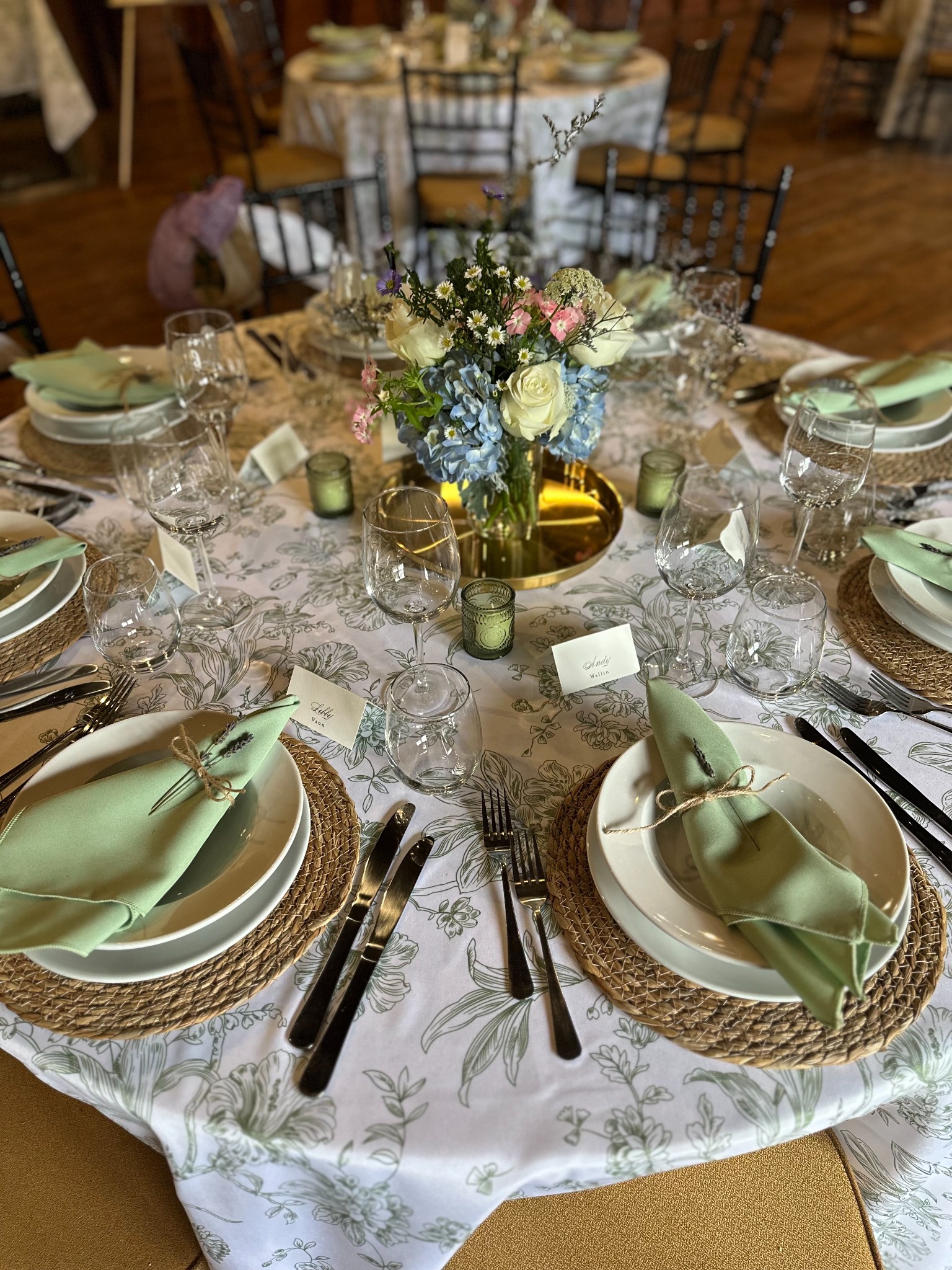 Closeup of a green botanical table setting with floral centerpiece